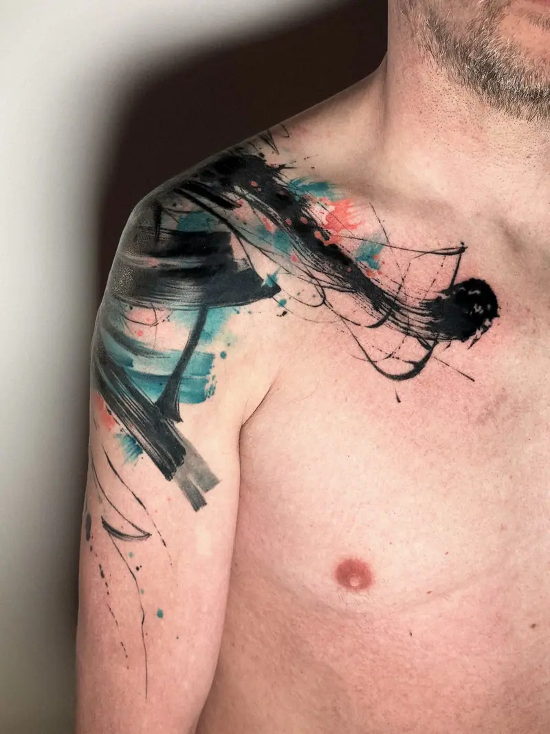 Abstraktes Brushstroke-Tattoo über Schulter und Brust, Pinselstriche in Schwarz und Türkis von Maya.