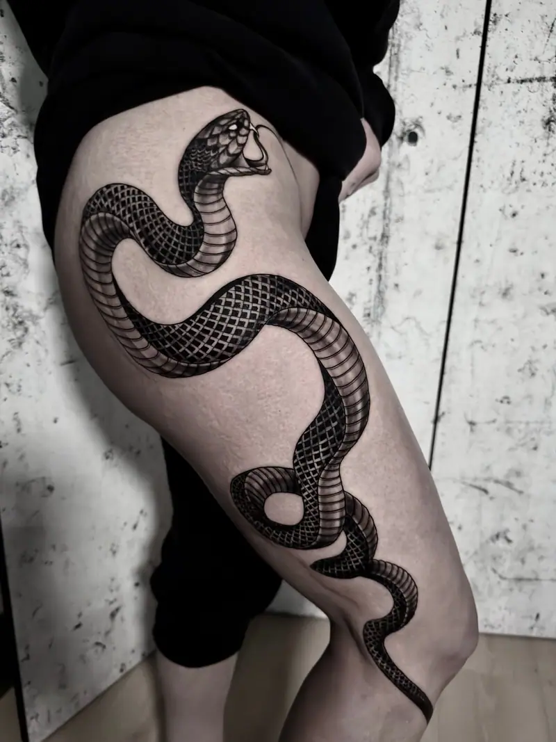 Kobra in Blackwork, die sich über den Oberschenkel windet — Schlangentattoo von Sabina.