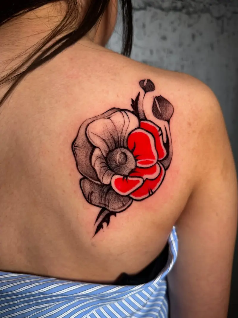 Detailansicht der Mohnblumen-Arbeit auf der Schulter, klare Linien und rote Akzente von Valeriia.