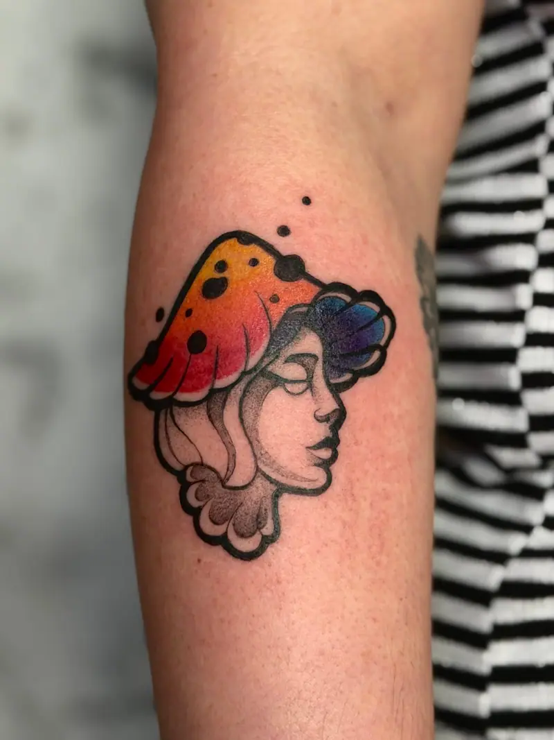 Illustratives Frauenporträt mit Pilzhut in kräftigen Farben am Arm, tätowiert von Valeriia.